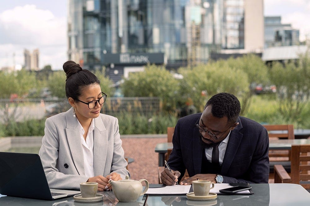 businesses - man signing document in front of a woman