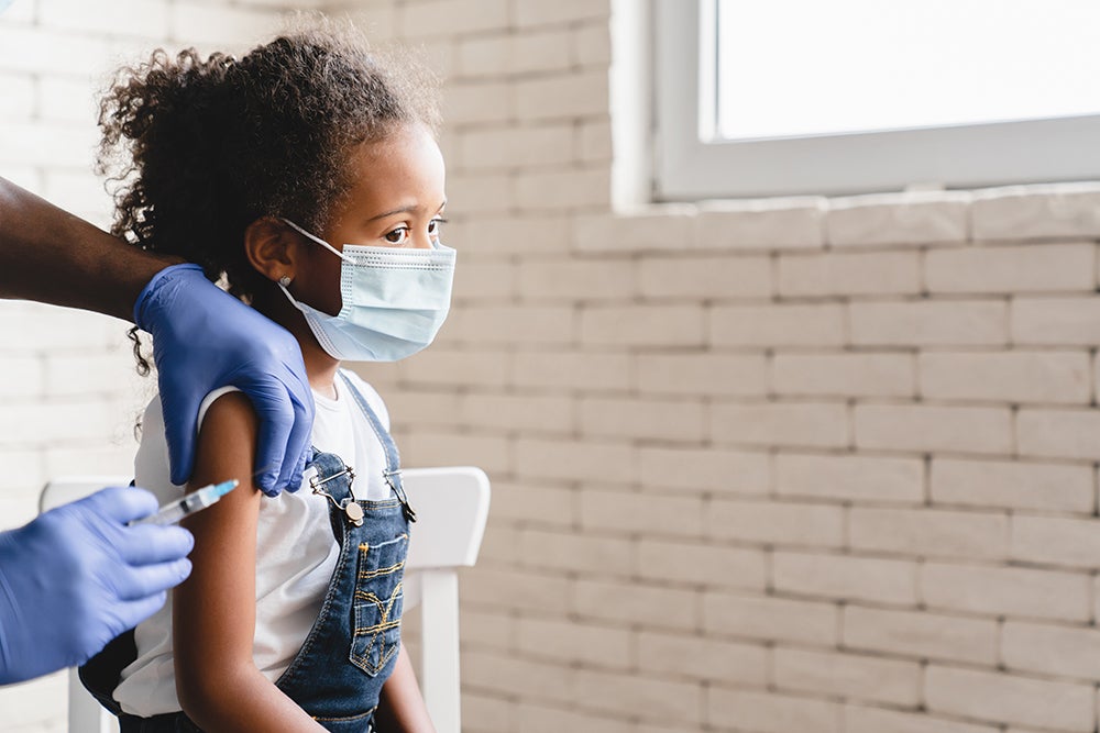 家庭——戴口罩的女孩正在接种疫苗