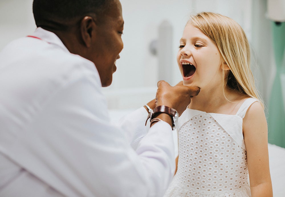 women and children - dentist looking at child's teeth