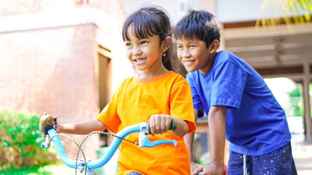 改善环境卫生——两个孩子骑自行车玩耍