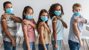 bivalent covid-19 vaccine booster - children with masks showing their bandaids