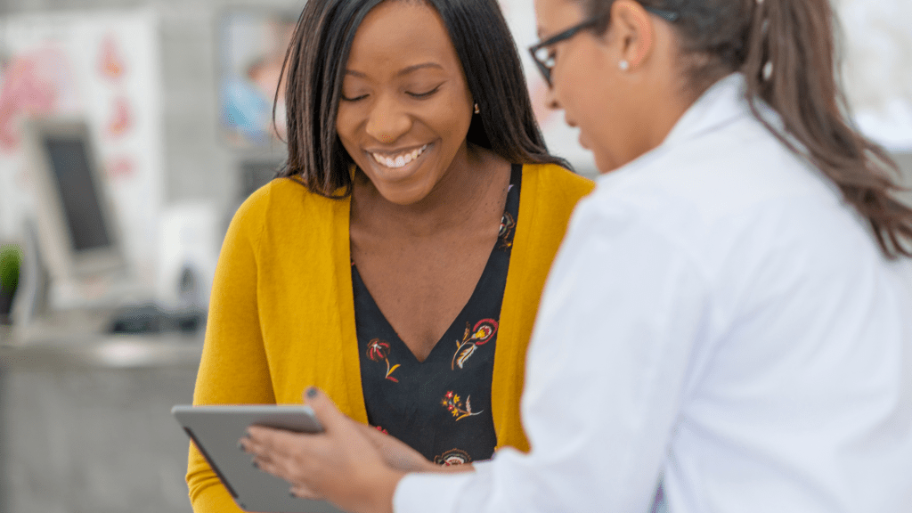 preventing stds/stis - woman showing another smiling woman a tablet