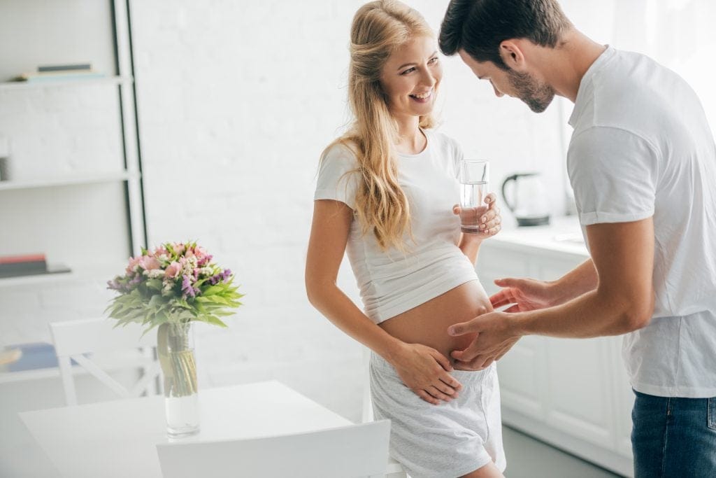 current health responses - husband touching belly of happy pregnant wife