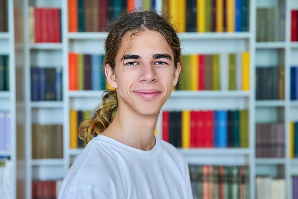 schools and daycares - smiling teen in library