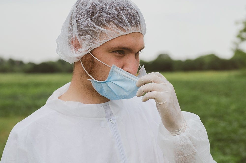 public health emergency preparedness - man in protective wear adjusting his mask