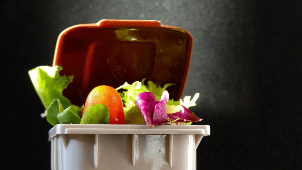 image of a trash can with vegetable scraps inside